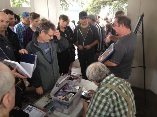Noted JFK conspiracy author Robert Groden (seated) hawks his wares in Dealey Plaza on Nov. 21.